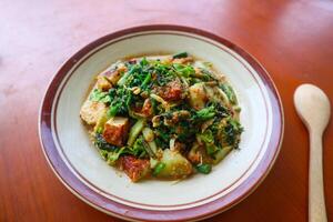 lotek is a traditional salad from Indonesia made from vegetable, chayote, kale, young jackfruit, tempeh, tofu, long beans, and bean sprouts with peanut sauce and cracker photo