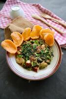 lotek is a traditional salad from Indonesia made from vegetable, chayote, kale, young jackfruit, tempeh, tofu, long beans, and bean sprouts with peanut sauce and cracker photo