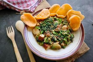 lotek is a traditional salad from Indonesia made from vegetable, chayote, kale, young jackfruit, tempeh, tofu, long beans, and bean sprouts with peanut sauce and cracker photo