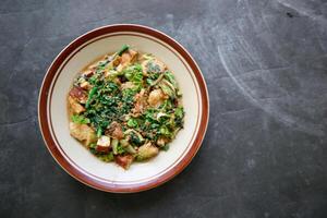 lotek is a traditional salad from Indonesia made from vegetable, chayote, kale, young jackfruit, tempeh, tofu, long beans, and bean sprouts with peanut sauce and cracker photo