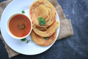 Roti Canai or Paratha Bread with Curry Sauce, Chilli Flakes and Yogurt, Top View photo