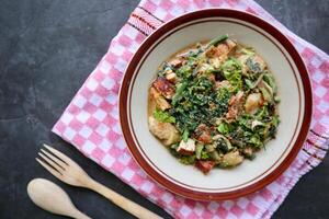 lotek is a traditional salad from Indonesia made from vegetable, chayote, kale, young jackfruit, tempeh, tofu, long beans, and bean sprouts with peanut sauce and cracker photo