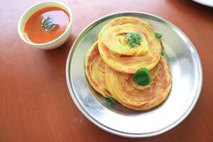 Roti Canai or Paratha Bread with Curry Sauce, Chilli Flakes and Yogurt, Top View photo