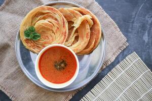 Roti Canai or Paratha Bread with Curry Sauce, Chilli Flakes and Yogurt, Top View photo