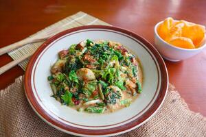 lotek is a traditional salad from Indonesia made from vegetable, chayote, kale, young jackfruit, tempeh, tofu, long beans, and bean sprouts with peanut sauce and cracker photo