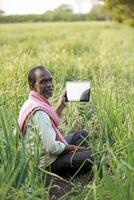 Indian farm worker holding tablet photo