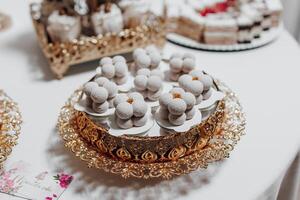 A tray of pastries with a floral design sits on a table. The pastries are small and round, and they are arranged in a way that makes them look like flowers. The tray is made of gold photo