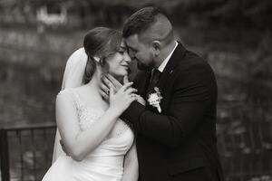 A bride and groom are embracing each other in a black and white photo