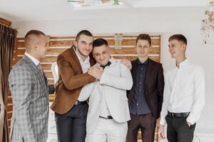 A group of men are hugging each other in a room. Scene is warm and friendly photo