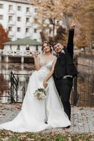 A bride and groom are posing for a picture with their hands on their hips photo