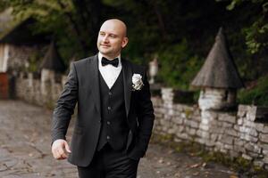A man in a suit and tie is walking down a path. He is smiling and he is happy photo