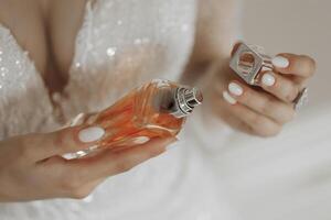 A woman is holding a bottle of perfume and the cap is open photo