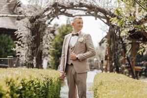 A man in a suit and tie stands in front of a gazebo photo