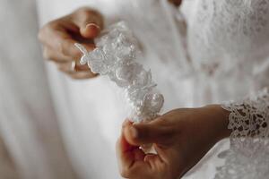 A woman is holding a white lace headband. The lace is delicate and intricate, and the woman is holding it with care. Concept of elegance and sophistication photo