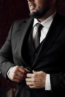 A man in a suit is getting ready for a formal event. He is adjusting his tie and jacket, making sure everything is in place. Concept of professionalism and attention to detail photo