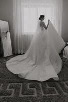 A woman in a wedding dress is standing in front of a mirror photo