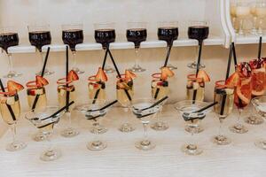 A row of wine glasses with straws in them and fruit garnishes photo