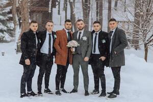 A group of men are posing for a picture in the snow. One of the men is holding a bouquet of flowers photo