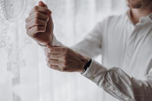 A man is getting dressed and adjusting his shirt. Concept of routine and daily life photo