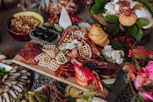 A table full of food with a variety of meats, fruits, and vegetables. The table is set for a party or gathering photo
