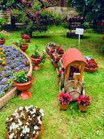 Gardens in the public park of Curtea de Arges Cathedral in Romania. Wooden train wagon and summer flower boxes photo