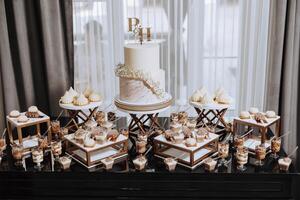 A table with a white cake and a couple of other cakes with the letters P and H on them photo