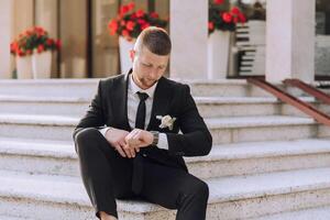 A man in a suit and tie is sitting on a set of stairs photo