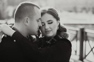 A man and woman are hugging each other on a bridge photo
