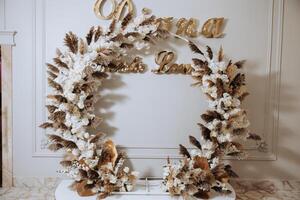 A large wreath with a gold border and white flowers. The wreath is decorated with gold and white flowers and has the name Diana on it photo