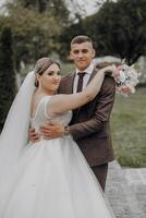 A bride and groom are posing for a picture in front of a tree photo