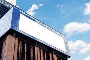 Mock up white horizontal billboard on mirror wall building with blue sky background .clipping path for mockup photo