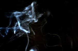 Ethereal Wisps of Smoke on a Dark Background Creating a Mysterious and Abstract Atmosphere photo