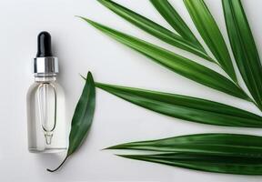 Essential Oil Dropper and Bottle on Green Leaves photo