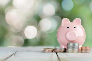 Piggy Bank and Coins on Wooden Table photo