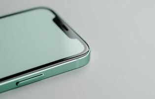 Green Smartphone on White Table With Pink Flowers photo