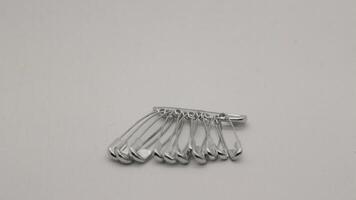 The safety pin is made of metal and silver in color. photo