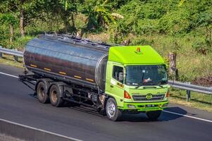 a large tank truck carrying oil or lubricants or chemicals that passes on a toll road, Indonesia, 16 July 2024. photo