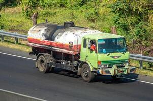 a large tank truck carrying oil or lubricants or chemicals that passes on a toll road, Indonesia, 16 July 2024. photo