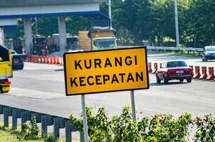 a warning sign to reduce speed on the toll road, Indonesia, 16 July 2024. photo