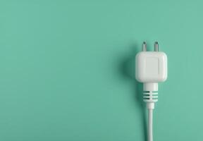 Two White Electrical Plugs on Teal Background photo