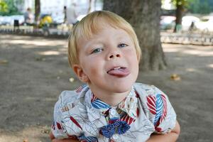 Blond boy 4 years old playing on a children playground and has fun. photo