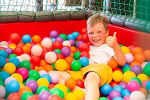 Boy playing on the playground, in the children's maze with balls. photo