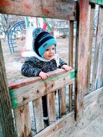 baby age of 1 year playing with sand on playground photo