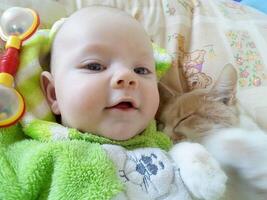 a little boy lovingly embraces and kisses a red cat photo
