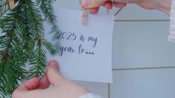 Dream board with message 2025 IS MY YEAR TO with fir branches. Happy new year resolutions promises concept. Visualizing creating vision board. Achievement setting goals video