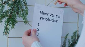 NEW YEAR'S RESOLUTION paper note on Dream board promises and aims. Preparation for new year new life new me. Visualizing wish list for 2025. Dreams plan action for coming year. Inspirational self improvement concept video
