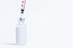Vaccine vial bottle with a syringe on a white background with copy space. photo