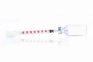 Medical syringe and vaccine vial isolated on a white background photo