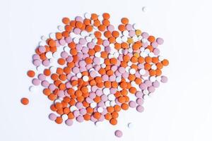 Pile of multicolored round pills on white background. photo