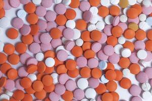 Close up of colorful round pills scattered on white background. photo